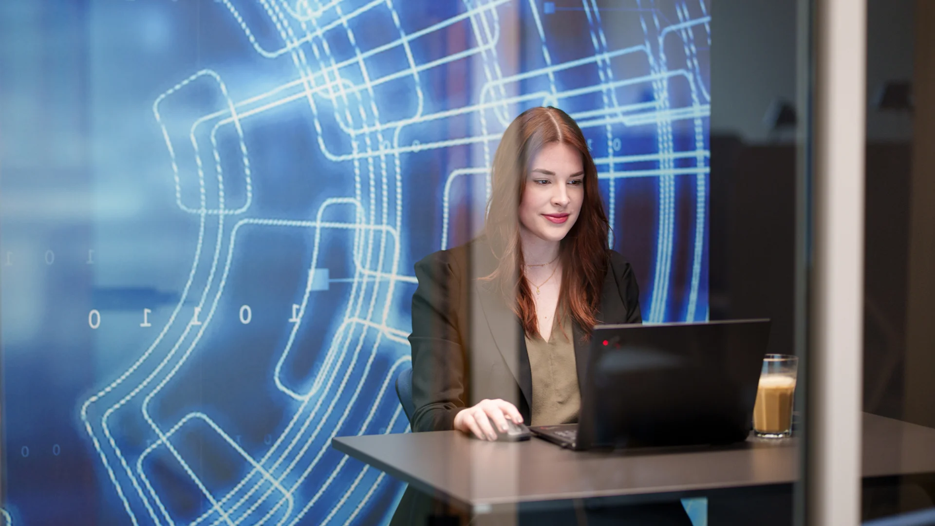 Mitarbeiterin von ai Consult arbeitet am Laptop in modernem Büro mit digitalem Hintergrund – steht für Digitalisierung, Innovation und attraktive Karrierechancen im Ingenieurwesen.