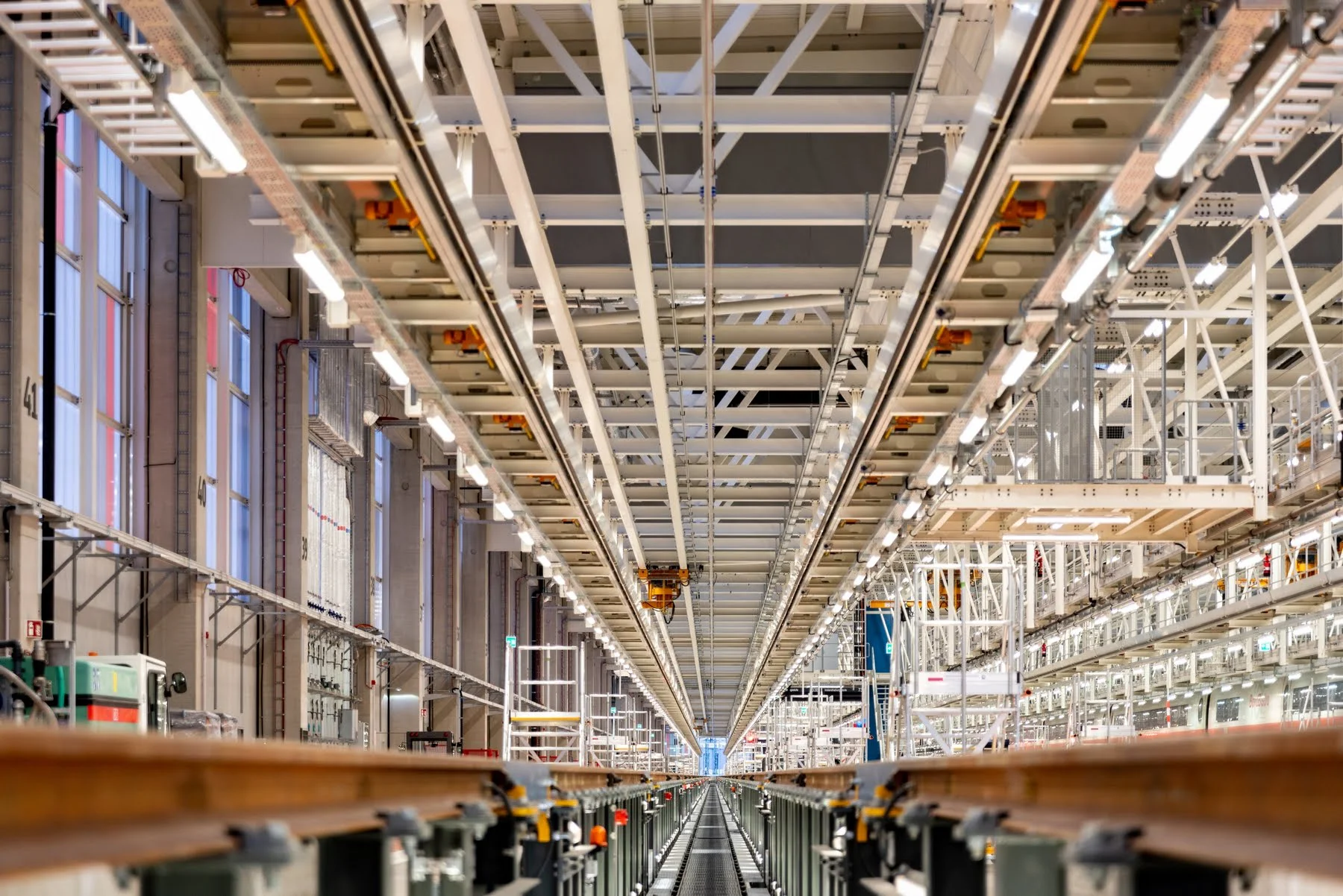 Innenansicht einer modernen Produktions- und Instandhaltungshalle mit Schienen und Stahlträgern – verdeutlicht Präzision, Technik und digitale Planungskompetenz der ai Consult GmbH.