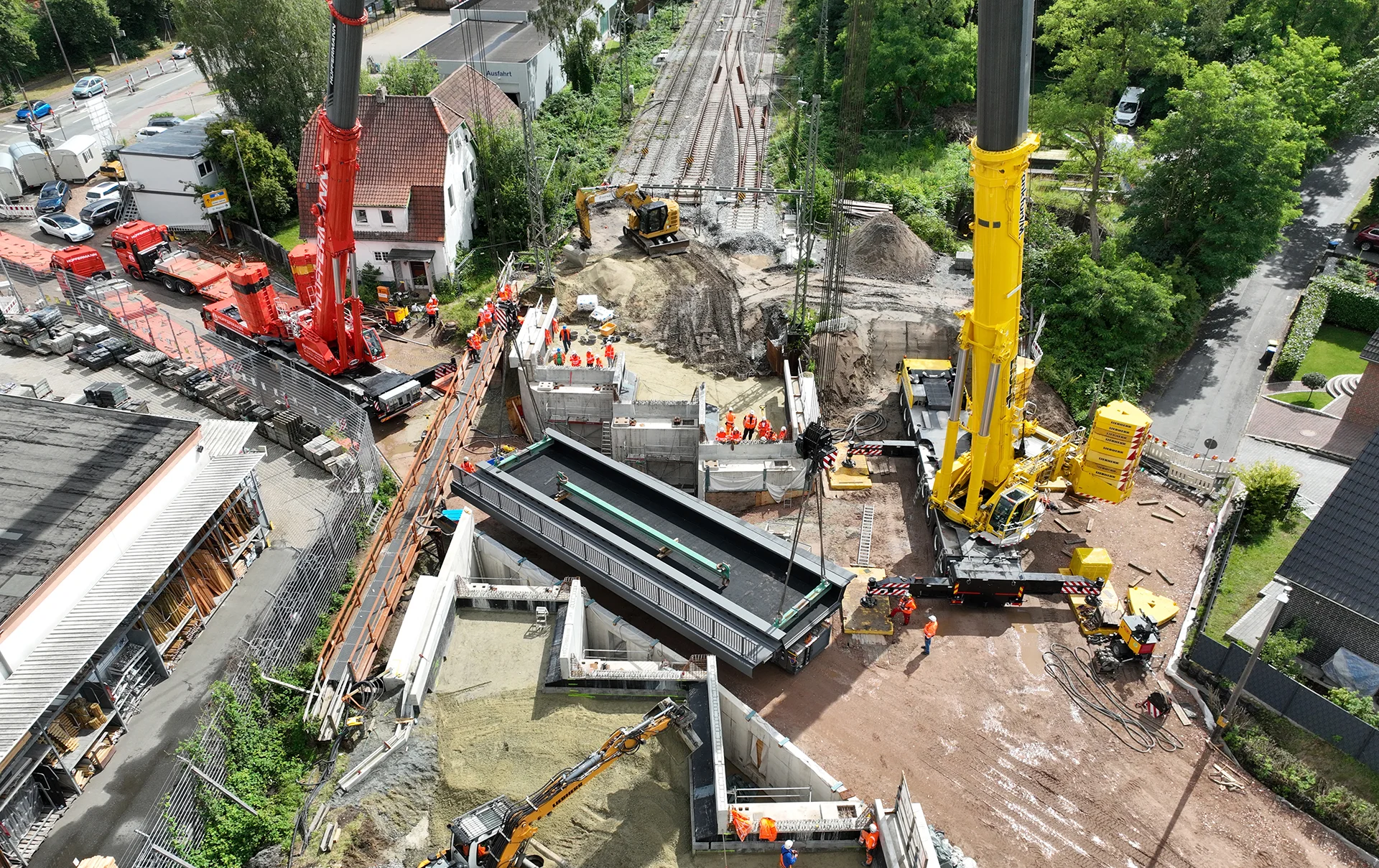 Luftaufnahme einer Bahnbaustelle mit Kränen, Gleisarbeiten und Baupersonal – zeigt die präzise Bauüberwachung und Koordination von Infrastrukturprojekten durch ai Consult GmbH.
